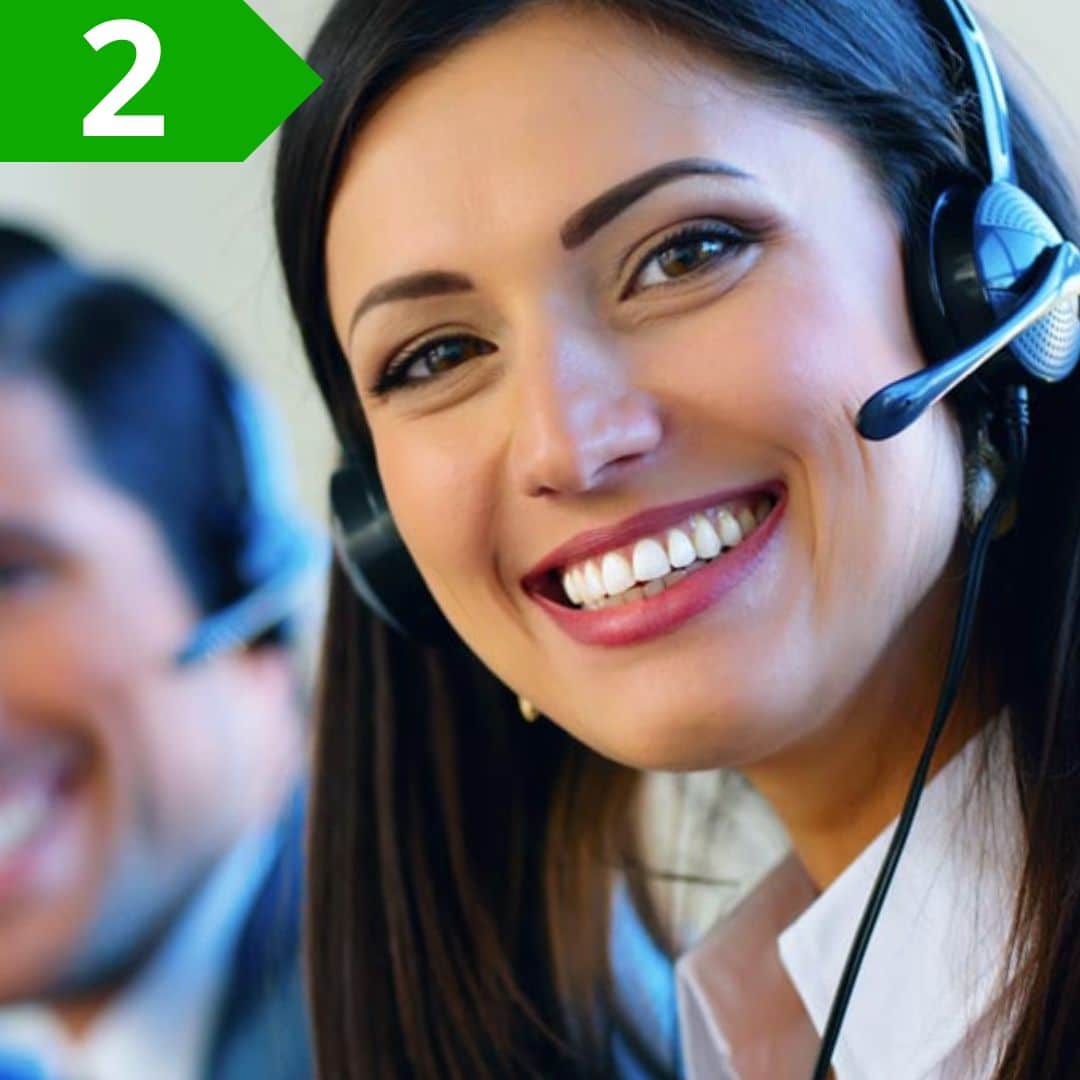 Donna sorridente con headset in call di assistenza clienti.