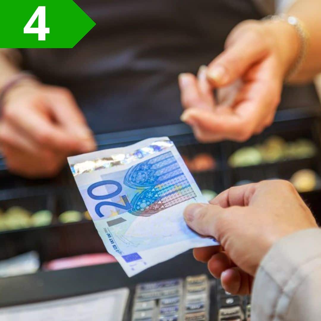 Transazione di pagamento con banconota da 20 euro in negozio.