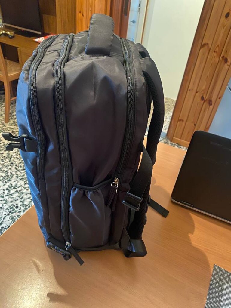 Zaino da viaggio nero con molte tasche e scomparti.