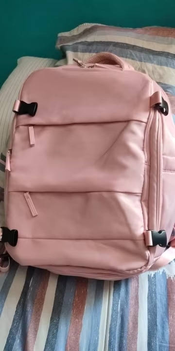 Zaino da viaggio rosa con scomparti e manici robusti.