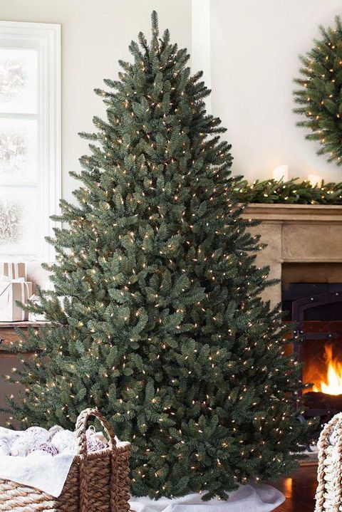 Albero di Natale verde alto 210cm decorato con luci calde.
