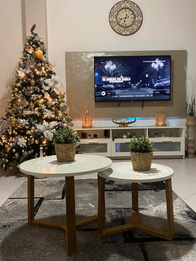 Albero di Natale decorato con luci e ornamenti in soggiorno moderno.