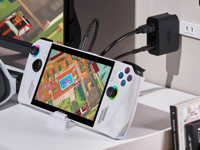 Console portatile con schermo di gioco retrò collegato a presa di corrente.