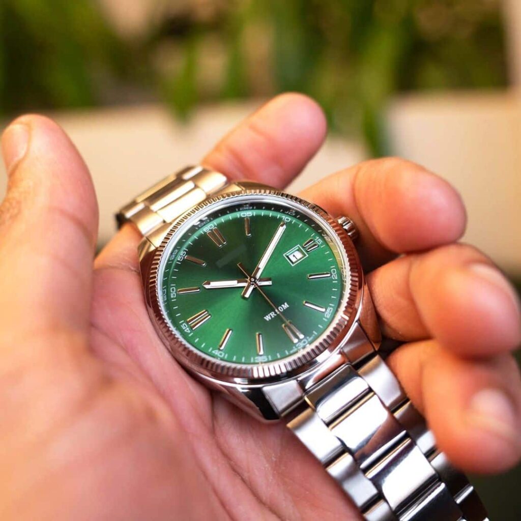 Orologio verde elegante con cinturino in acciaio, primo piano.