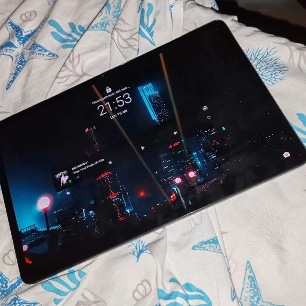 Tablet con schermo che mostra skyline urbano di notte.